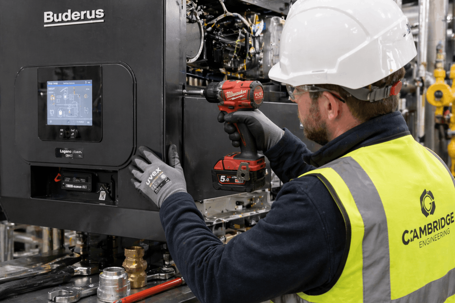 Detailed view of commercial boiler mounting and installation process in Cambridge industrial premises by qualified heating engineer