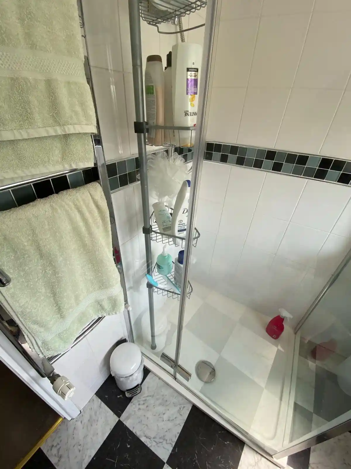 Bathroom shower enclosure with tiled walls and connected plumbing fittings