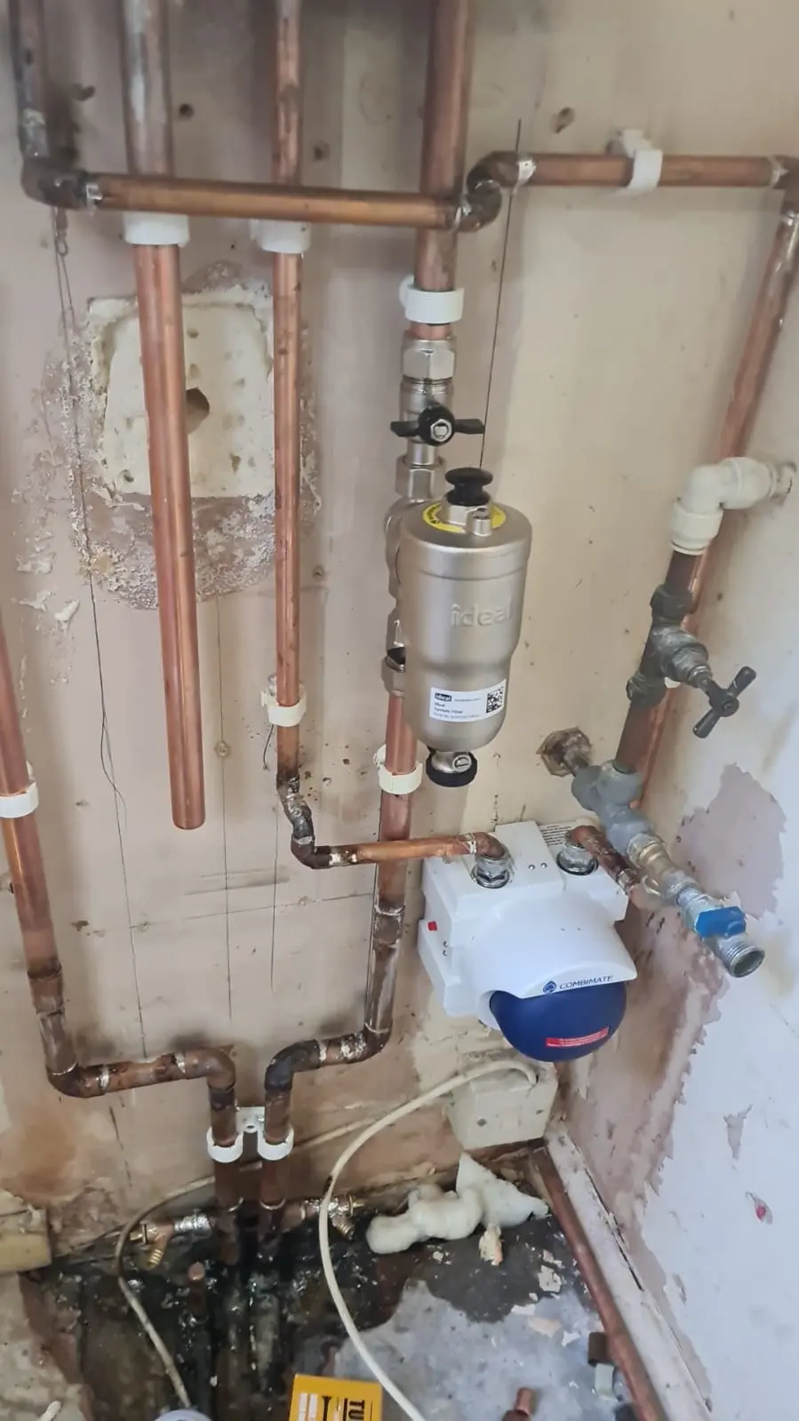 Exposed copper plumbing pipework with valves and inline system components