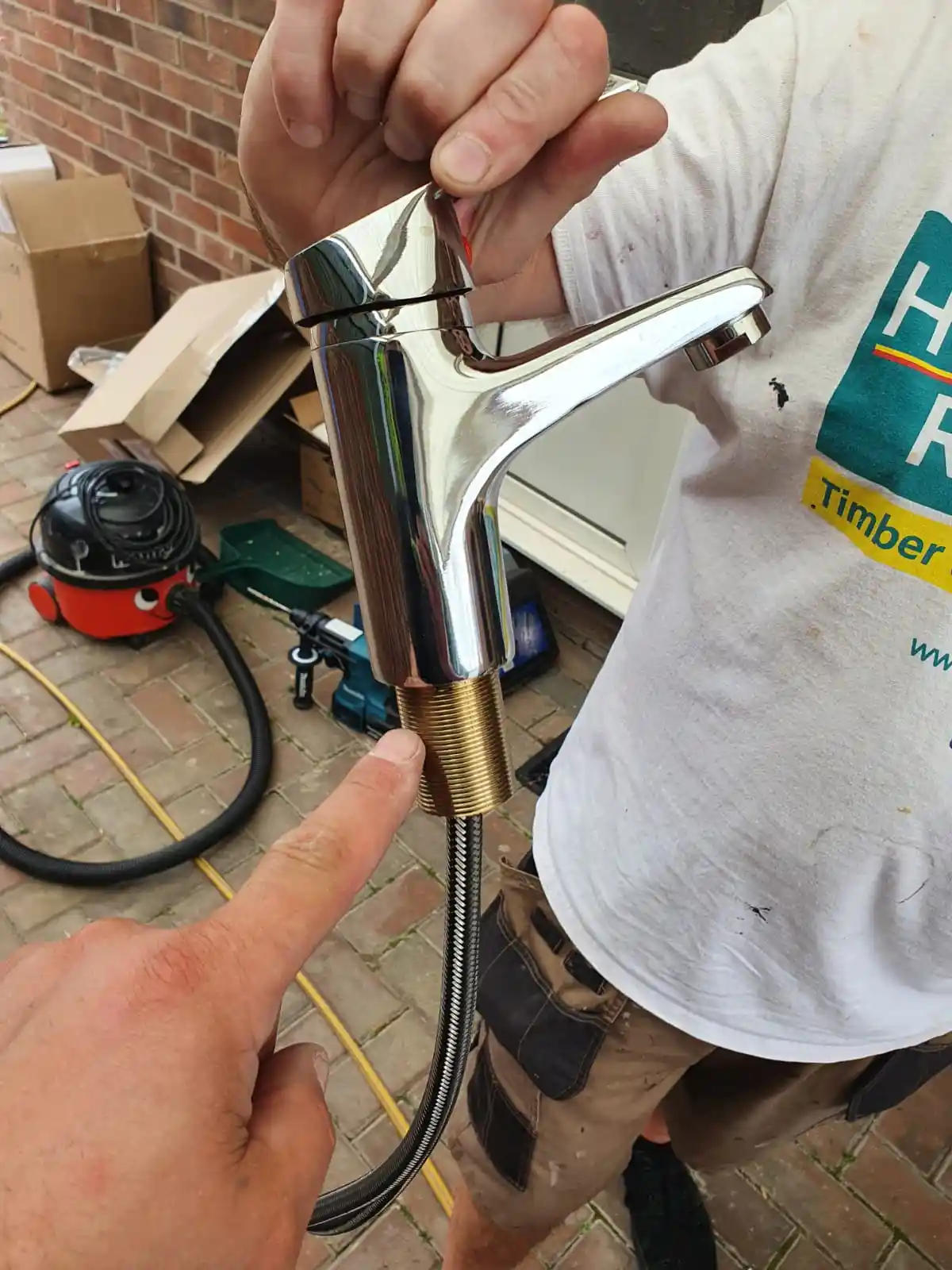 Plumber preparing a chrome mixer tap for installation